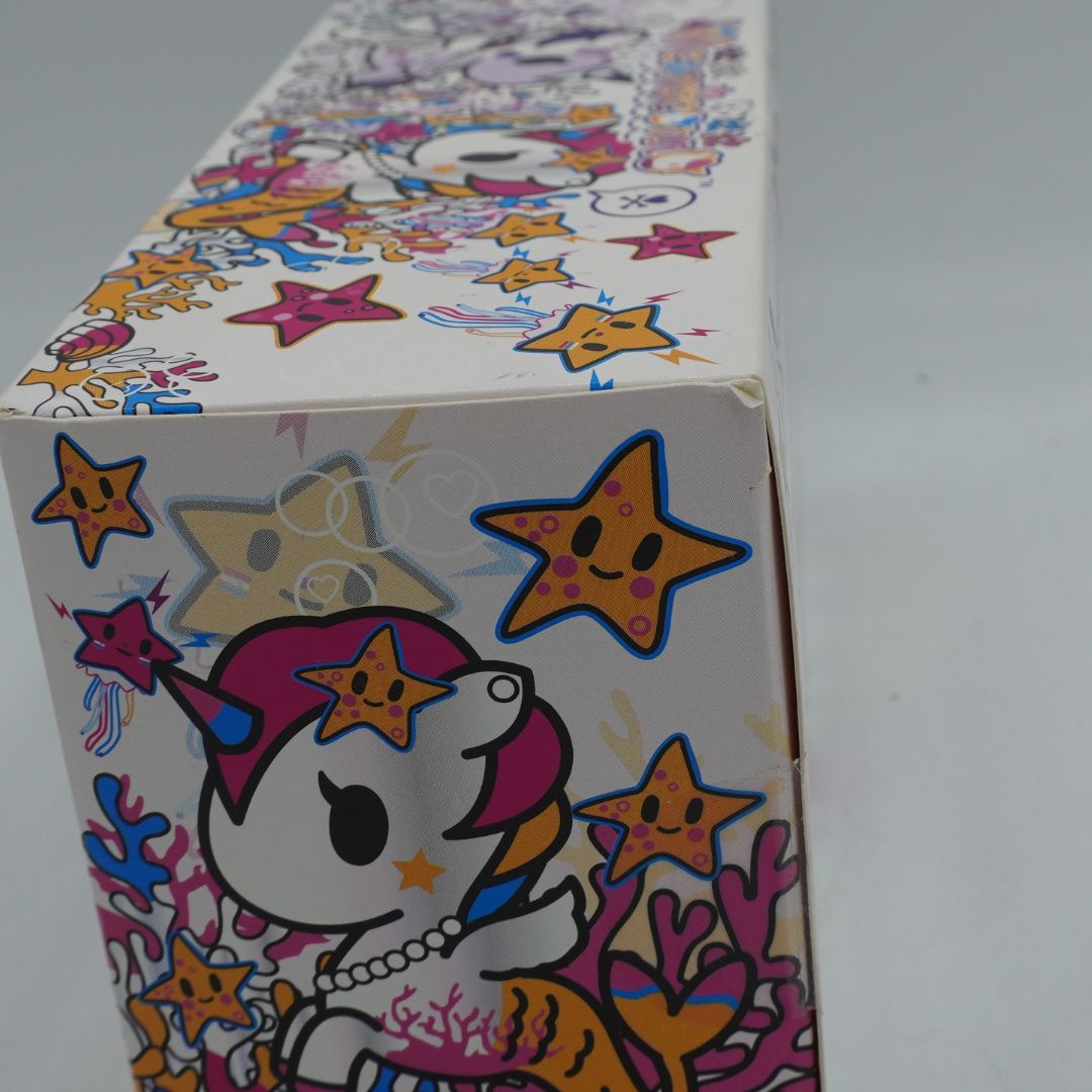 Photo of a colourful Mermicorno Tokidoki box with a set of two purple and white vinyl figurines