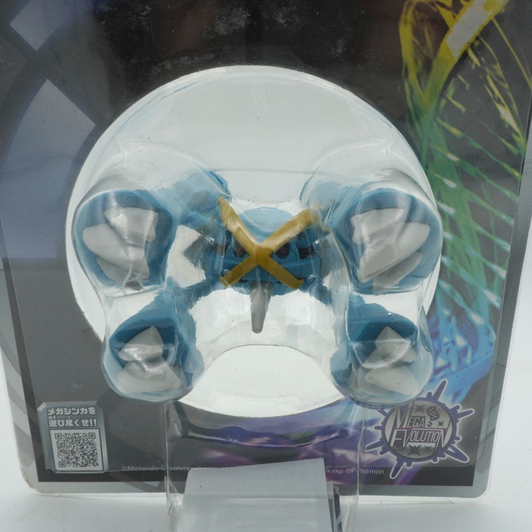 Toy figure in packaging with blue and white design on a reflective surface