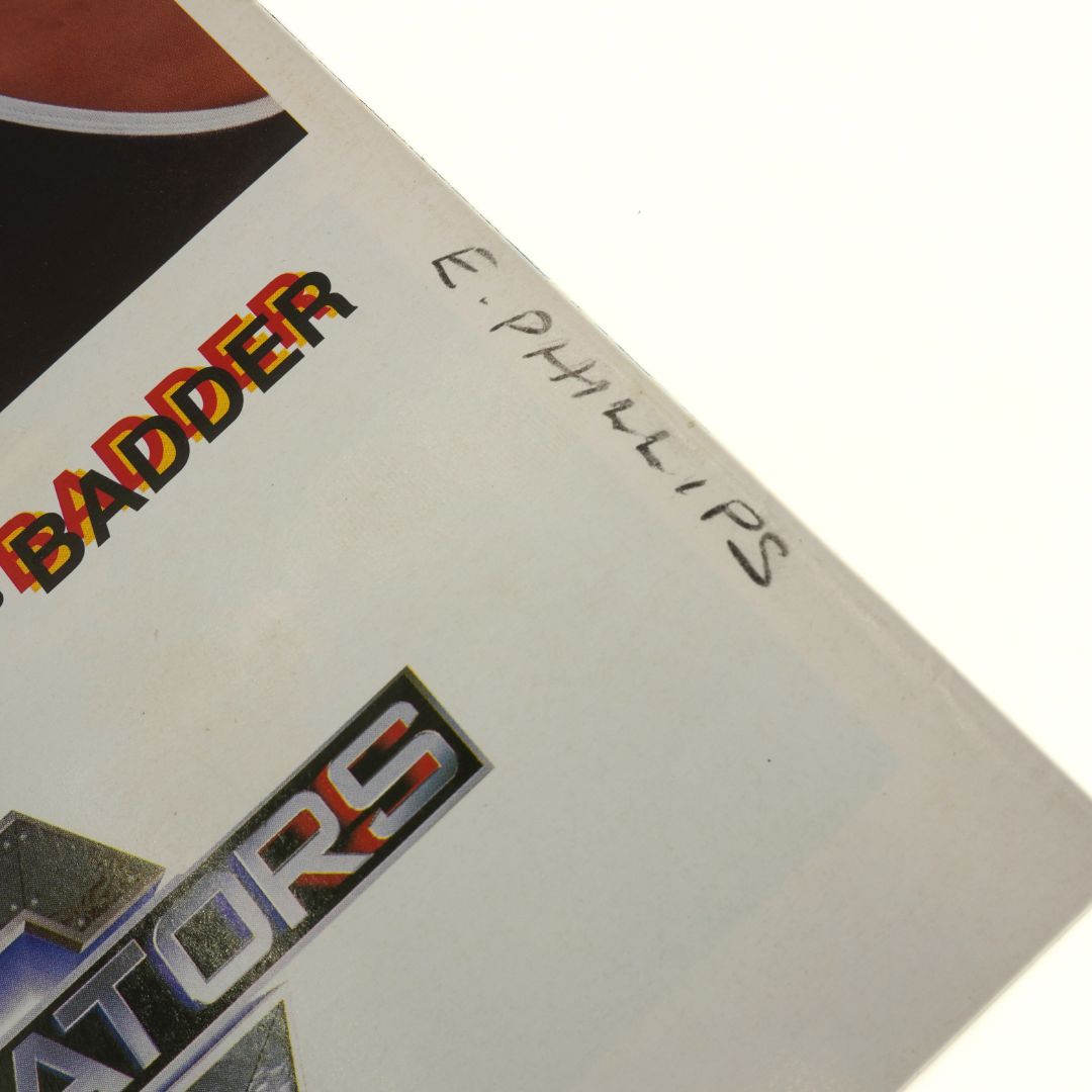 Close-up of a book cover with 'Badder' and 'Gladiators' text, and a signature on a white background.