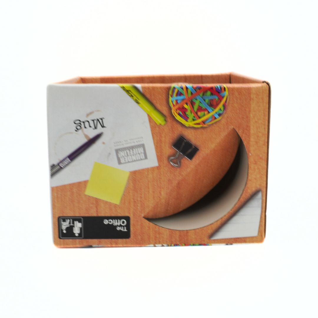 Office supplies including a pen, sticky notes, and rubber bands in a cardboard box hosting an Office themed mug