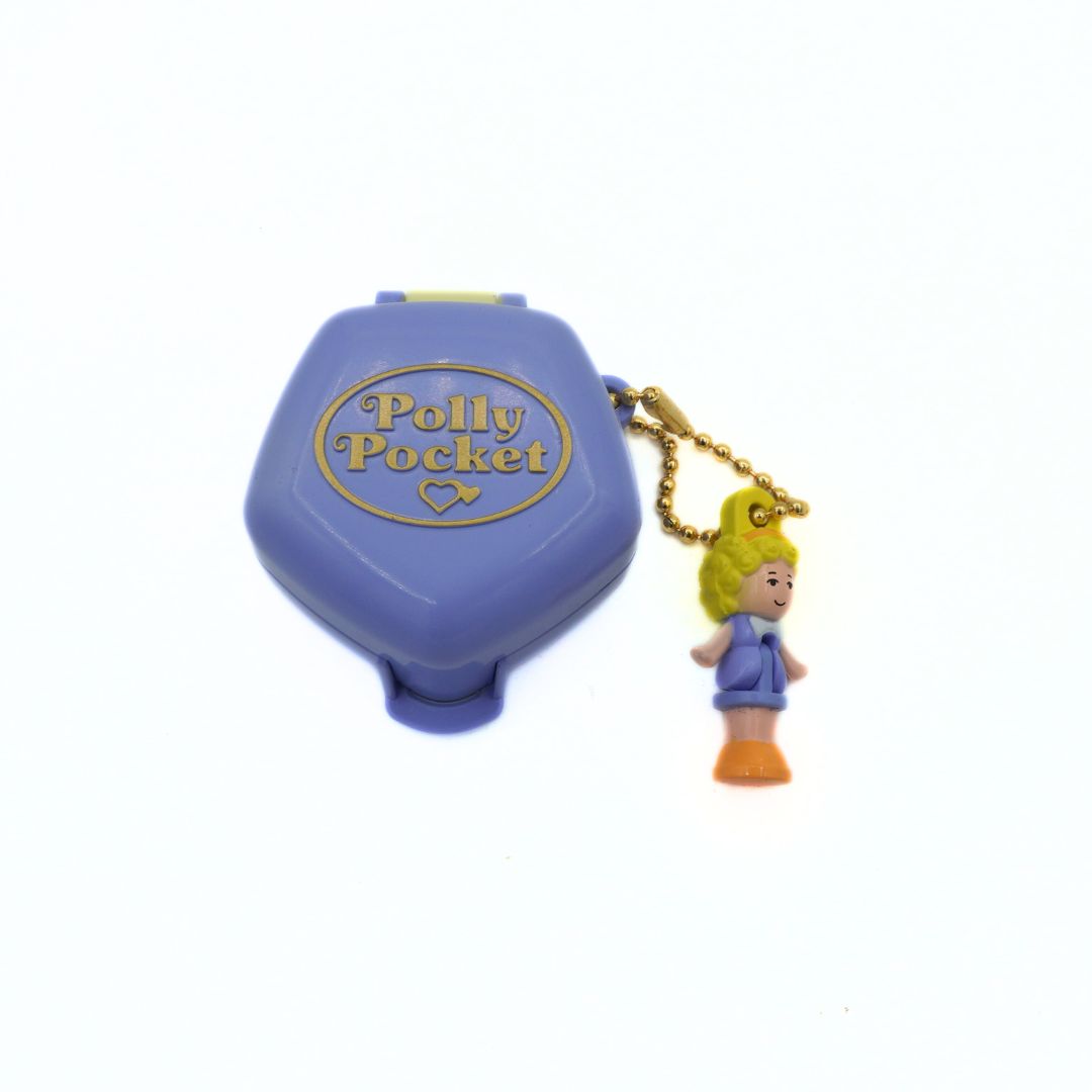 Polly Pocket keychain with purple case on a white background