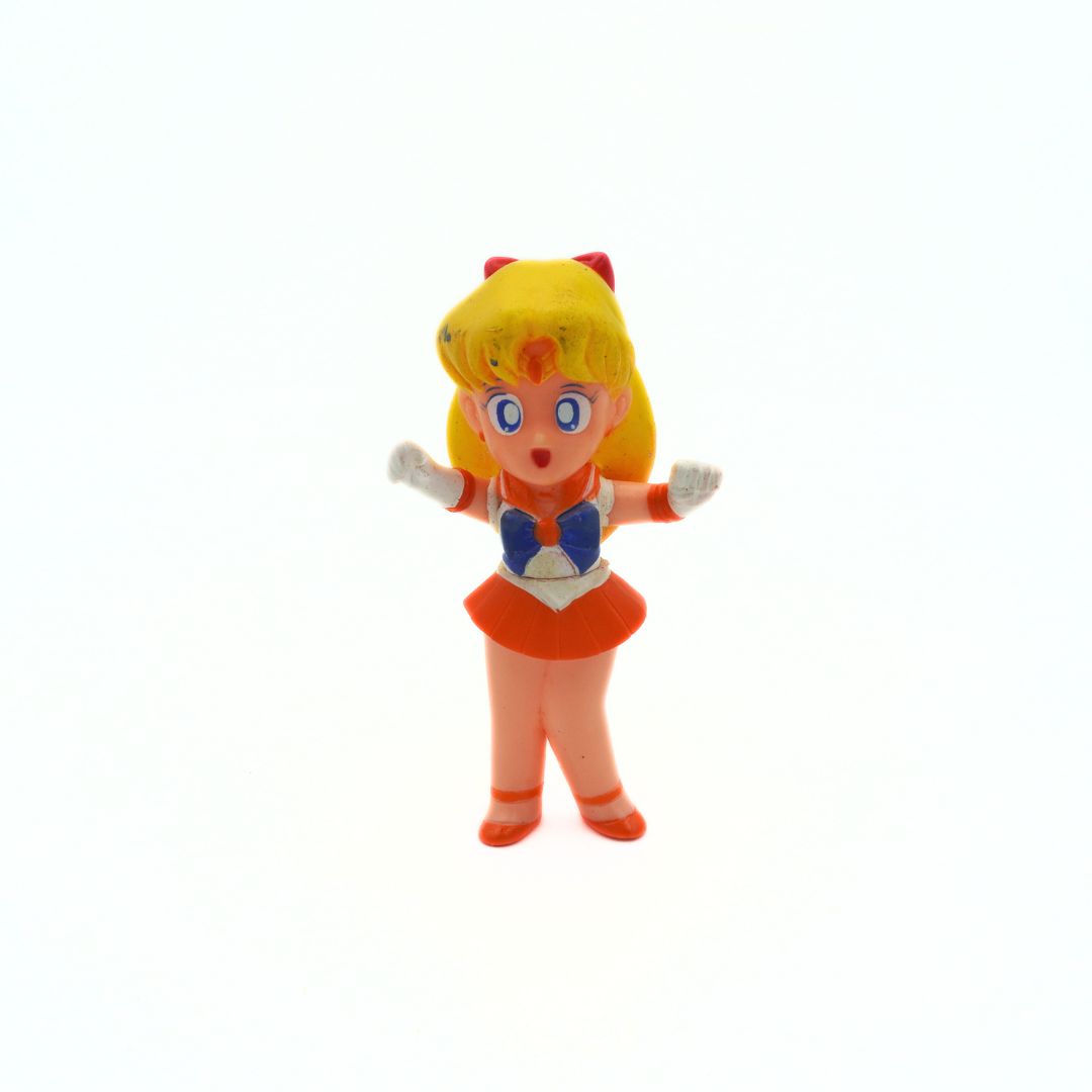 A 1994 Bandai Sailor Venus figurine with an orange and blue outfit and blonde hair