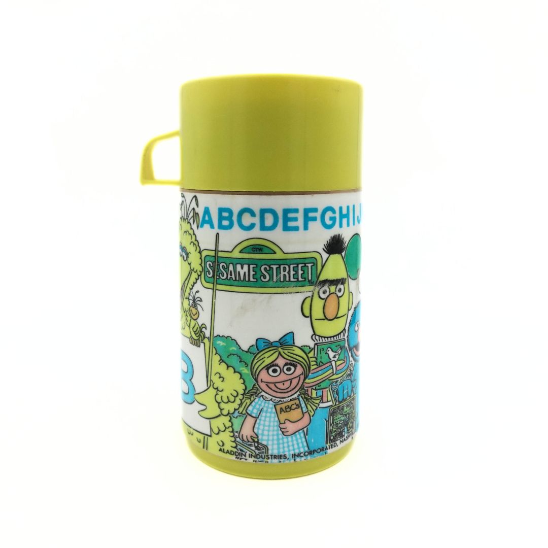 1979 Sesame Street thermal flask showing the alphabet, famous Sesame Street characters and a yellow lid