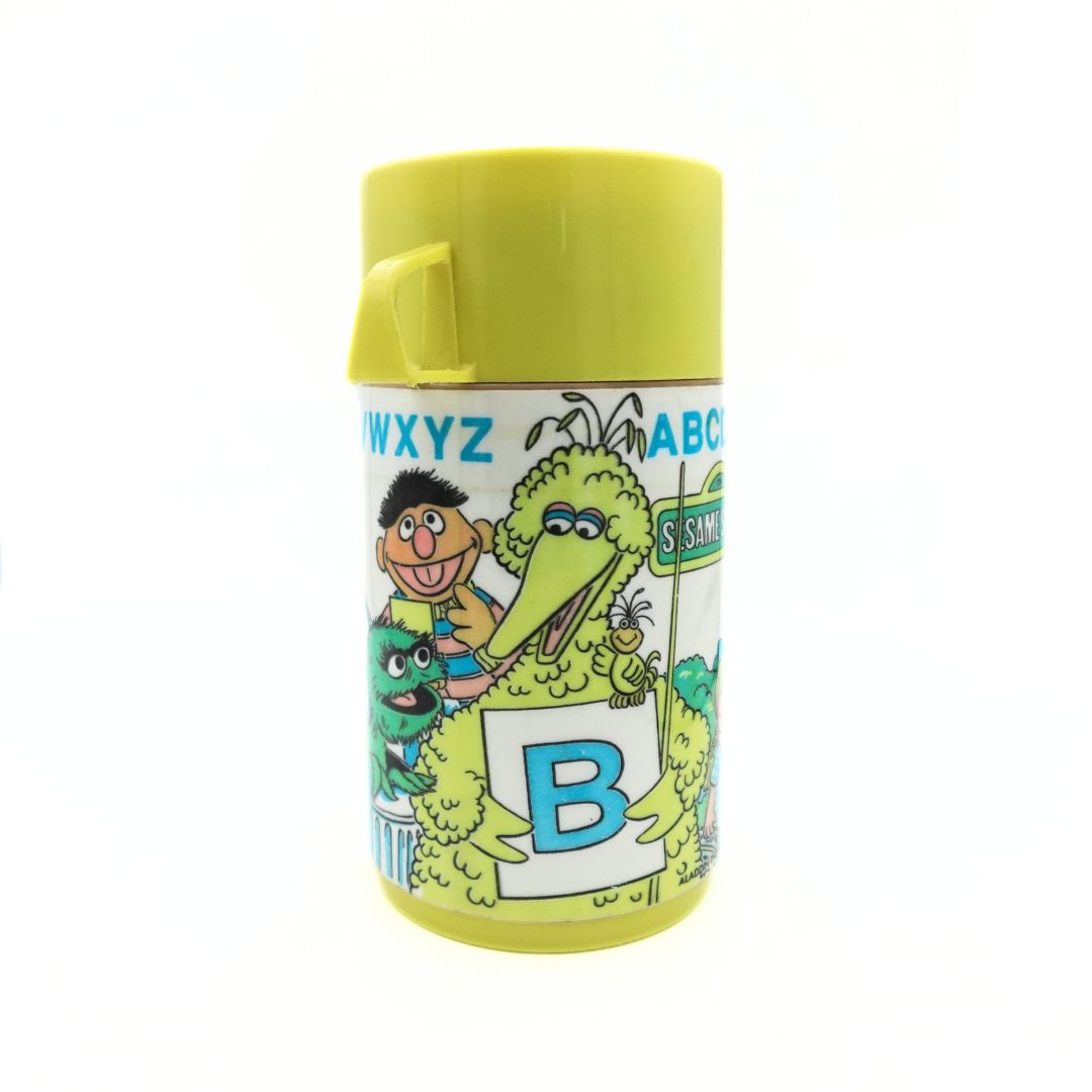 1979 Sesame Street thermal flask showing the alphabet, Big Bird holding a large B and a yellow lid