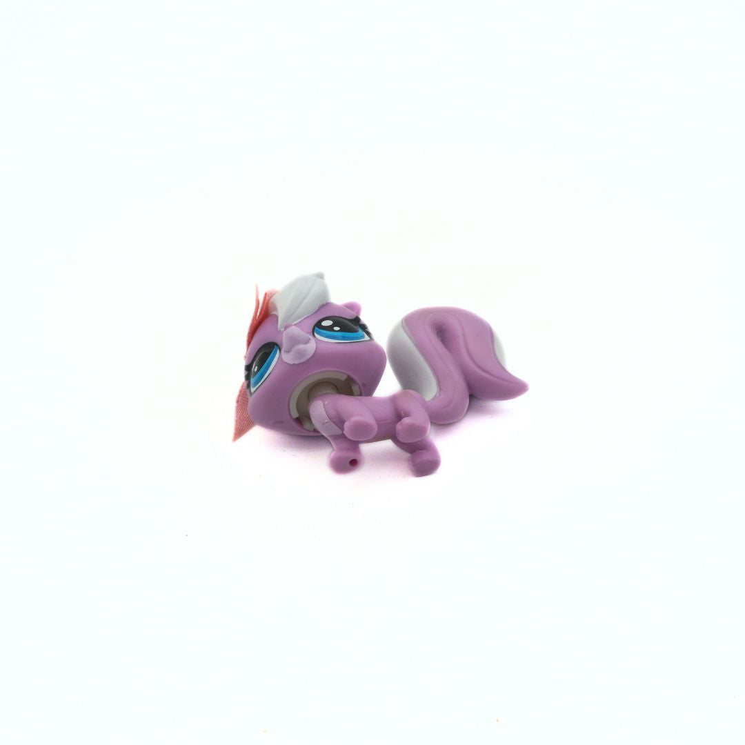 Small purple toy figure with a white mane on a white background
