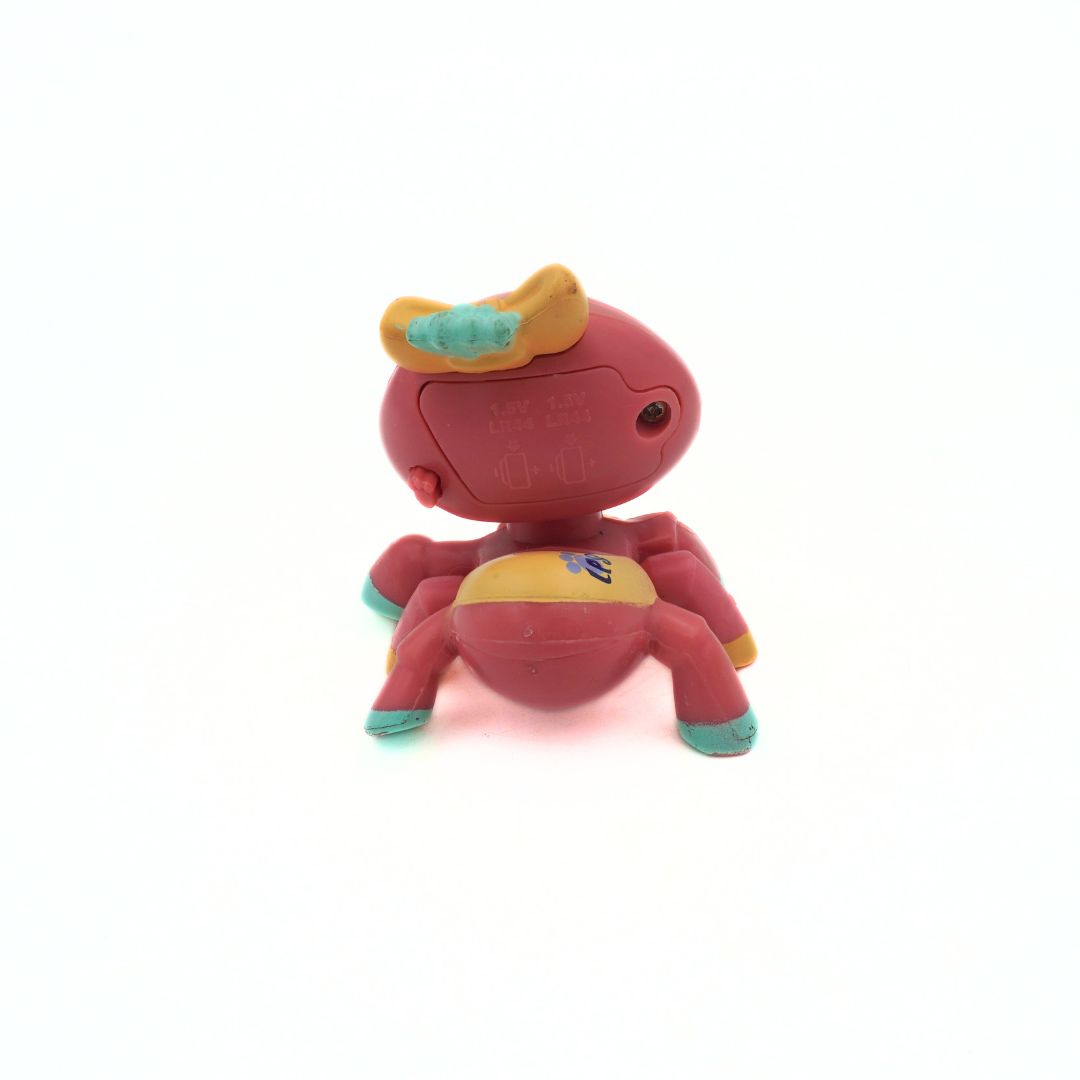 Back of a pink, green and yellow spider toy released by Littlest Pet Shop