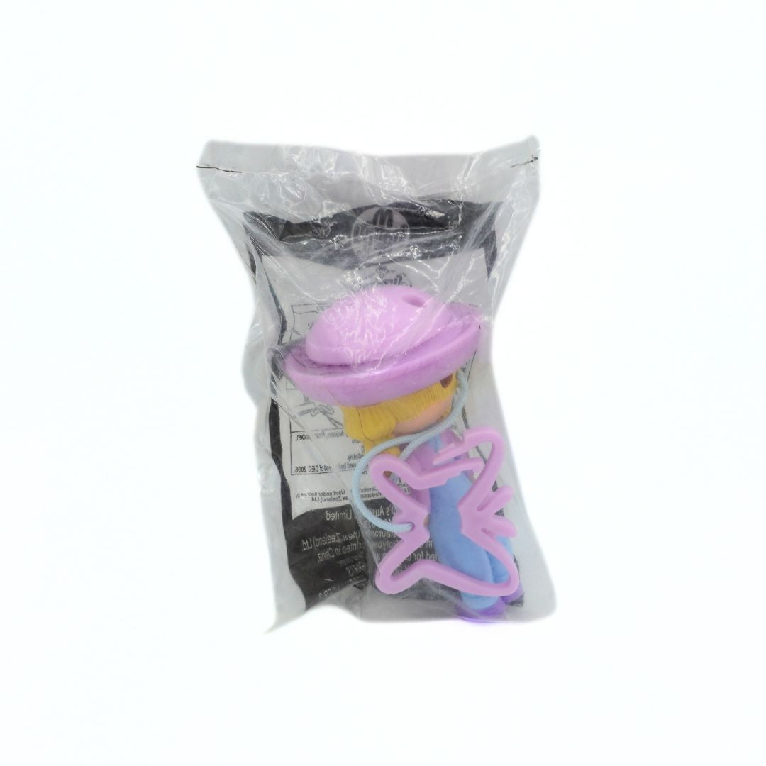 Plastic toy with a pink hat in a clear plastic bag on a white background