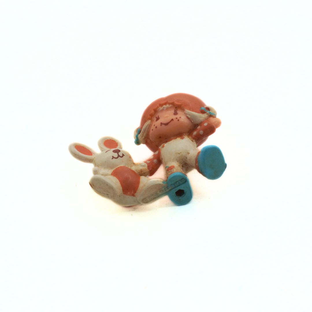 Small figurine of a character riding a scooter on a white background