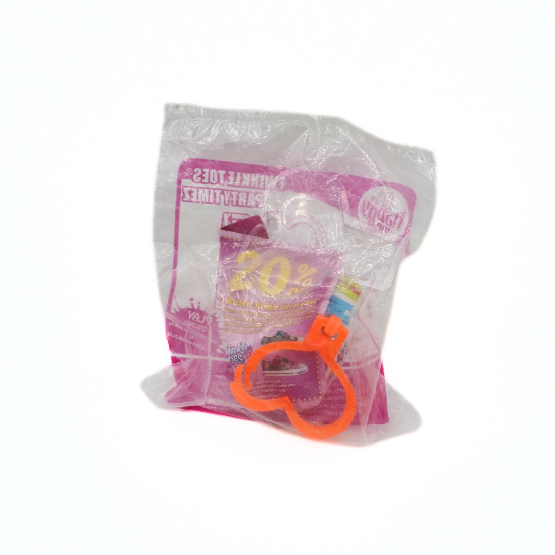 Package of a toy shoe keyring with a pink label and orange handle on a white background