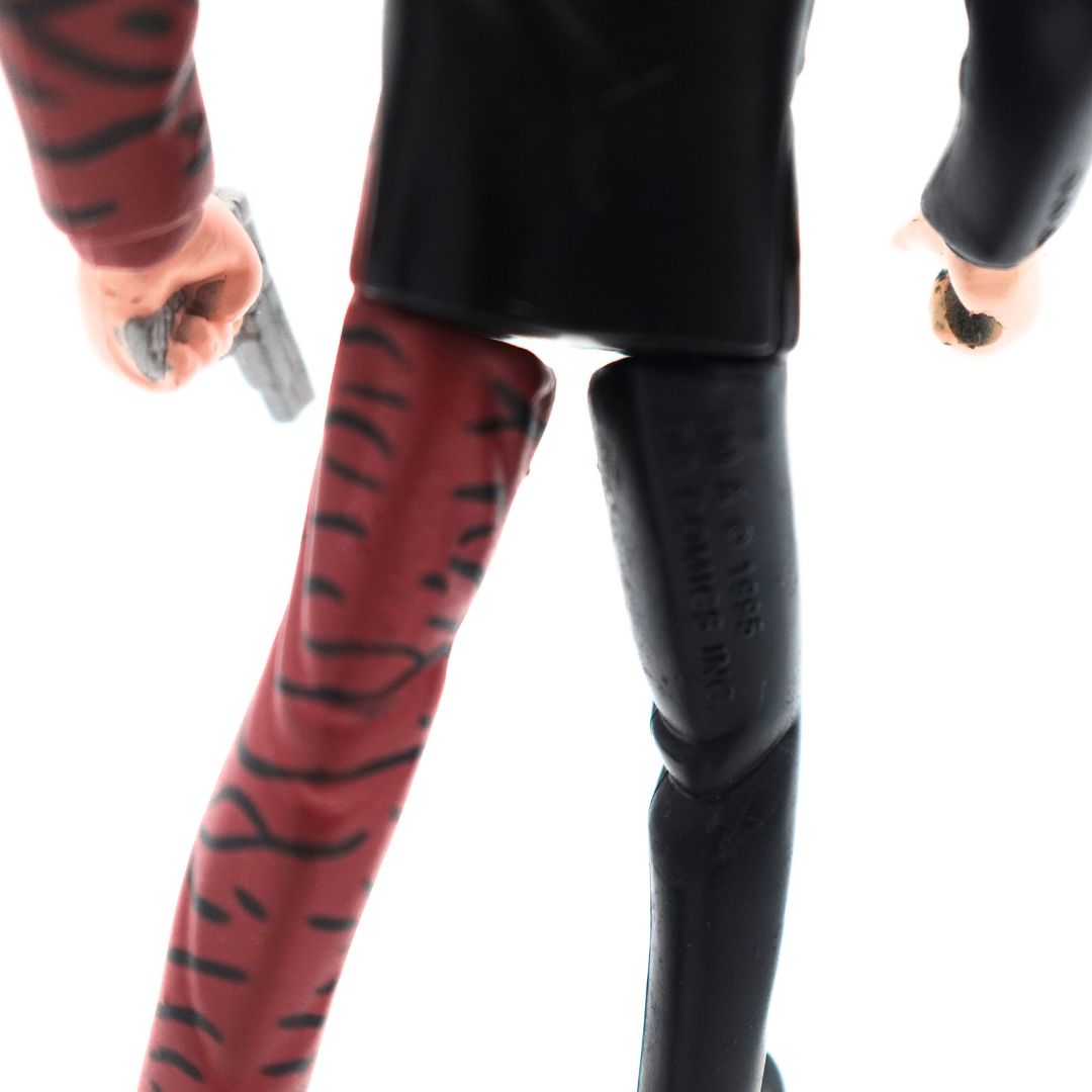 Branding on the back of the leg on a 1995 Batman Forever Two-Face figurine with a red and black suit