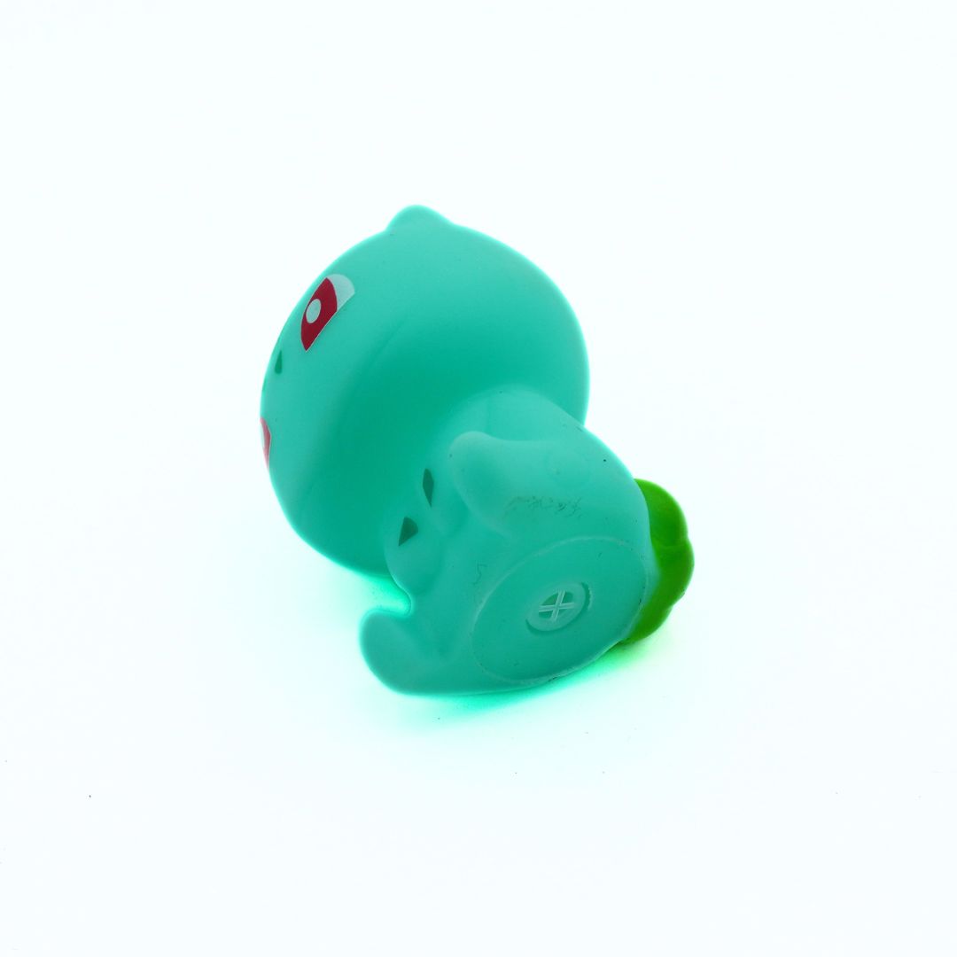 Green toy duck with a red heart on a white background