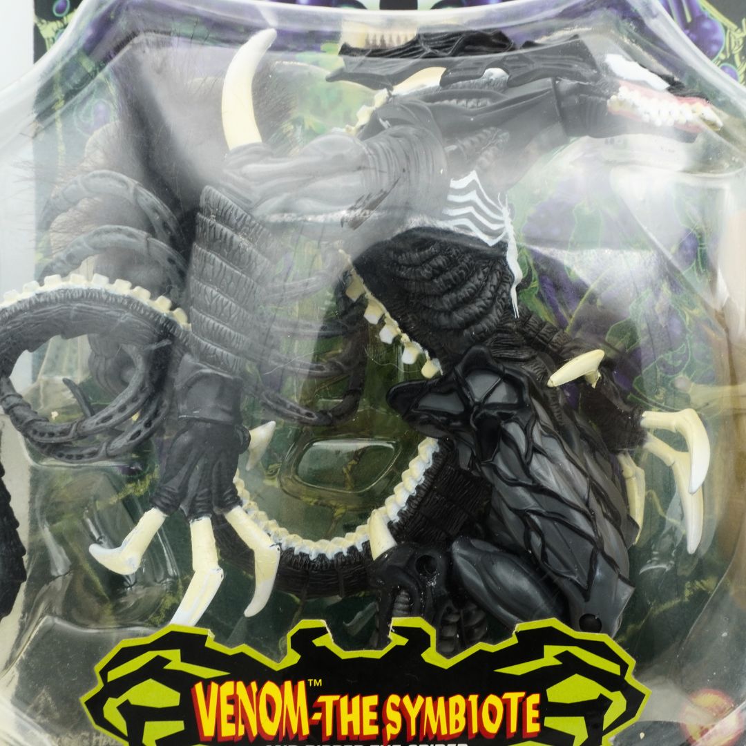 Closeup of a vintage 1997 Venom the Symbiote figurine seen through its plastic packaging