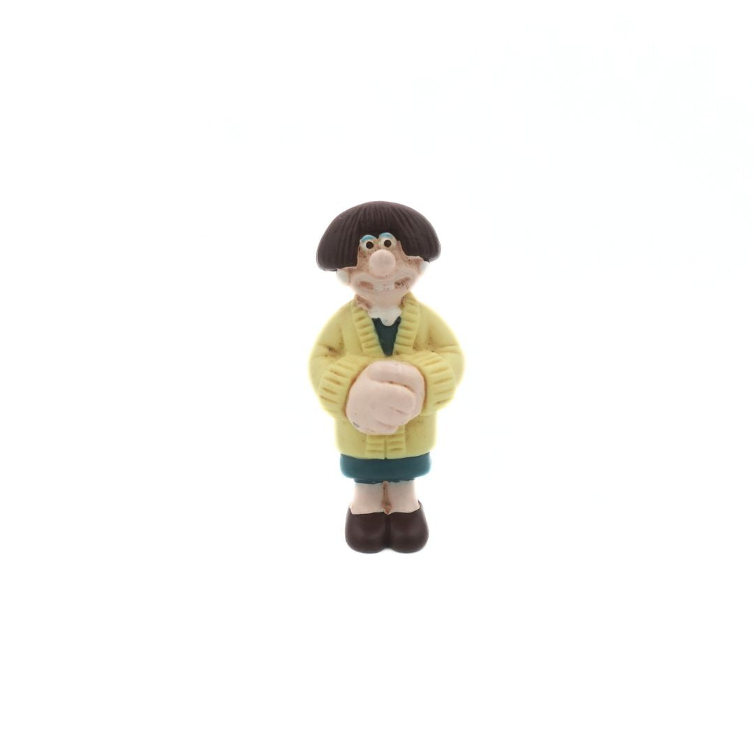 A mini figure of the Wallace & Gromit figure Wendolene Ramsbottom wearing a yellow cardigan and a green dress