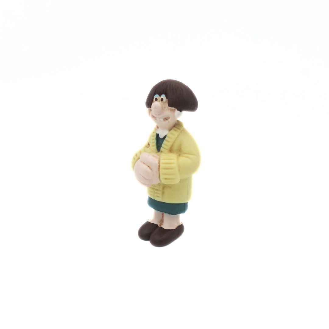 A mini figure of the Wallace & Gromit figure Wendolene Ramsbottom wearing a yellow cardigan and a green dress