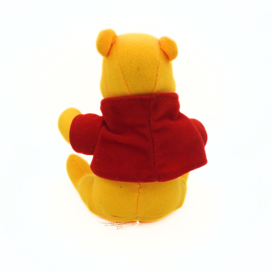 Plush yellow toy bear with a red jacket on a white background