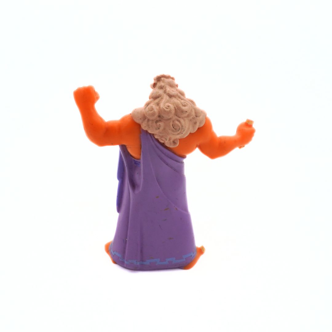 Toy figure of a character with orange hair and outfit on a white background