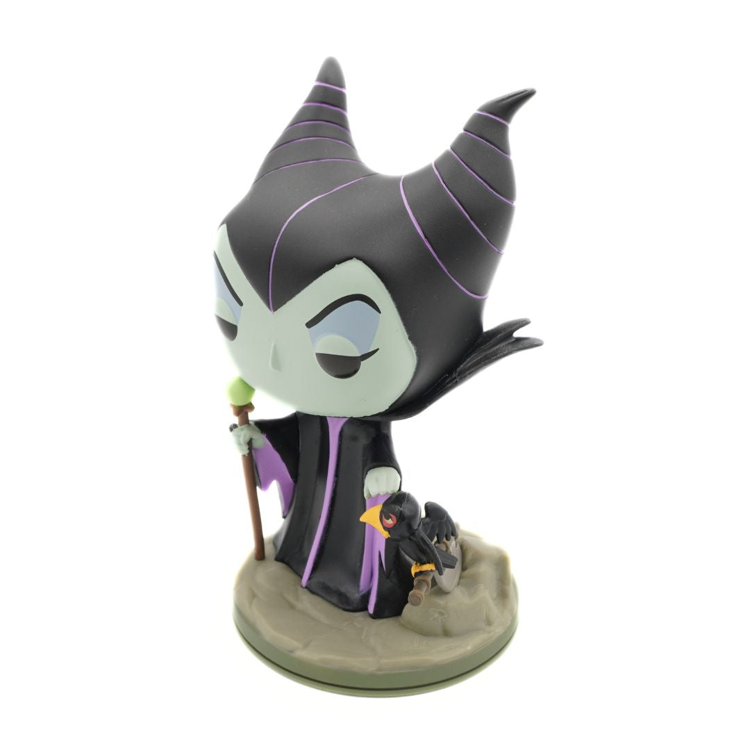A stylized Funko Pop! vinyl figure of Maleficent from Disney's The Princess and the Frog, standing on a gray rocky base with a small penguin figurine at her side, set against a plain white background.