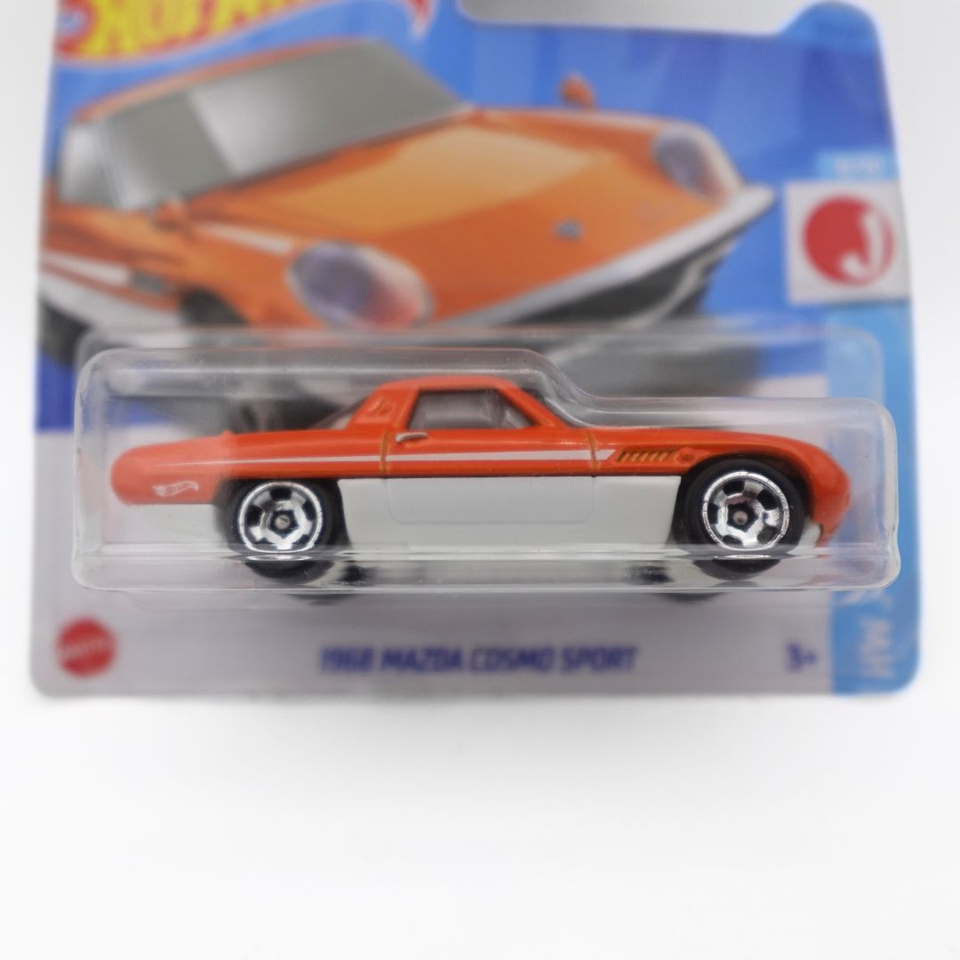 Close up of the 1968 Mazda Cosmo Sport Hot Wheels toy released in 2023, with an orange and white colour palette