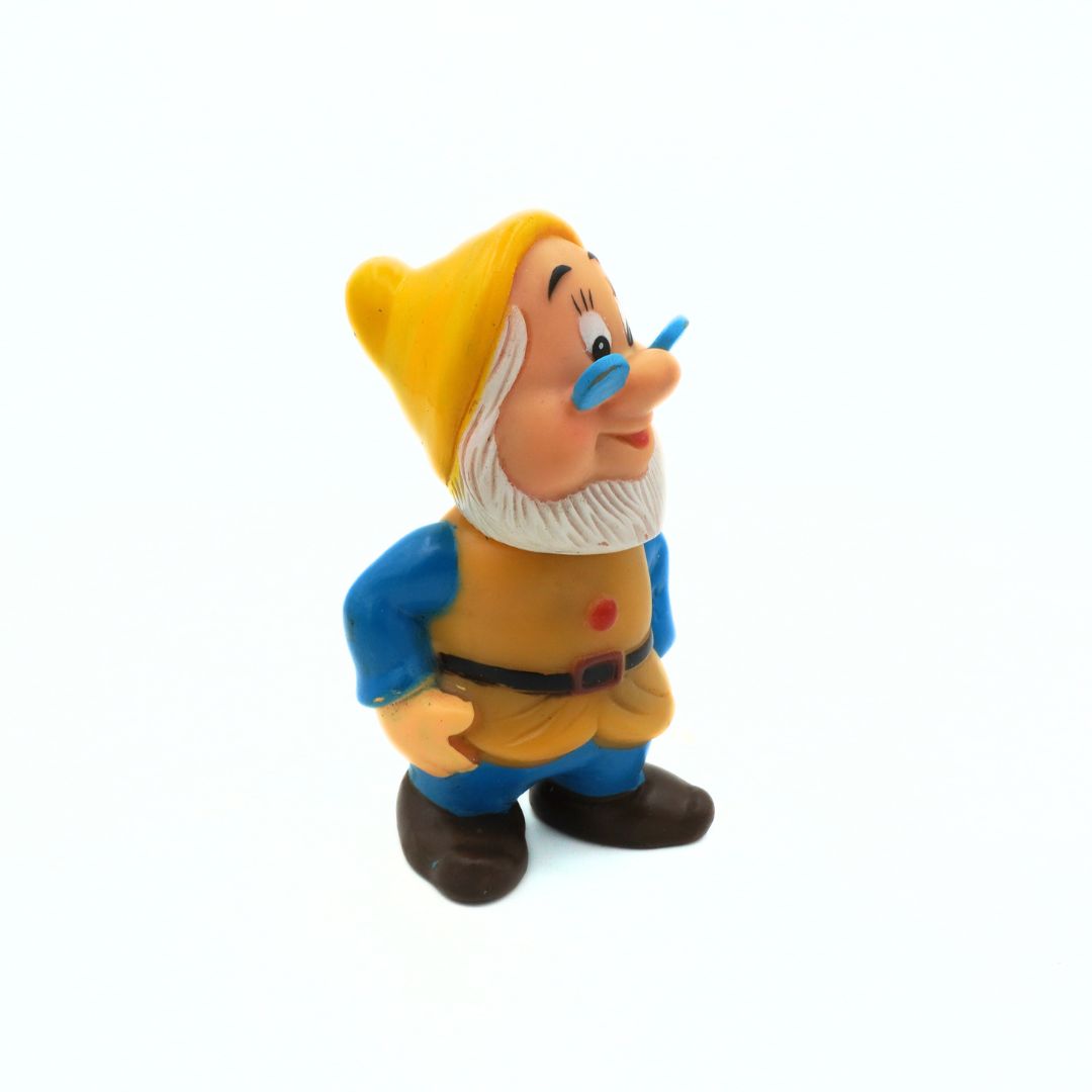 Animated character figurine with yellow hat and blue pants on a white background