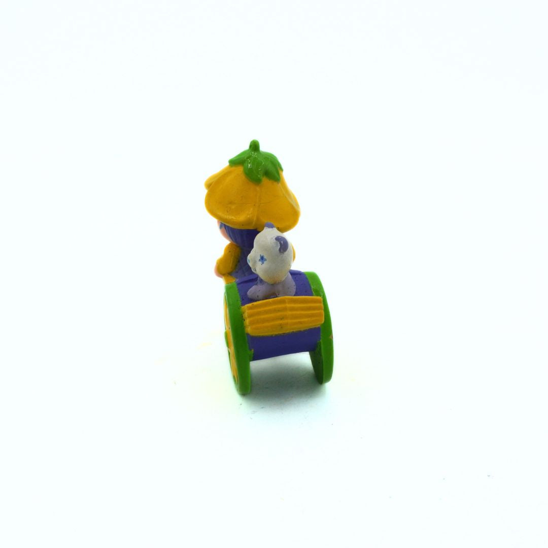 Toy figure of a character in a colorful cart on a white background