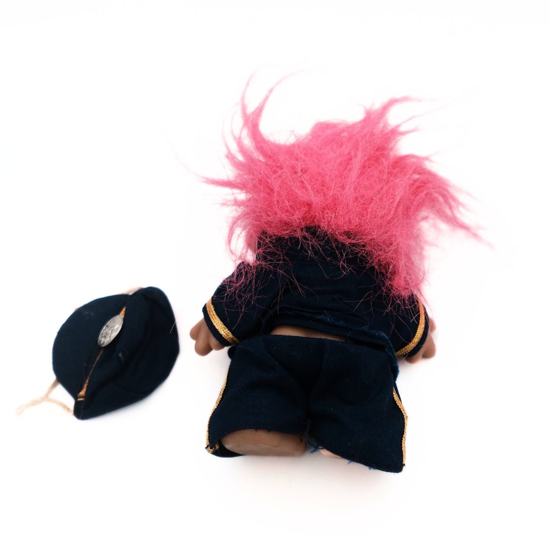 Back of a pink haired 1986 Troll Doll in a policeman uniform with hat accessory