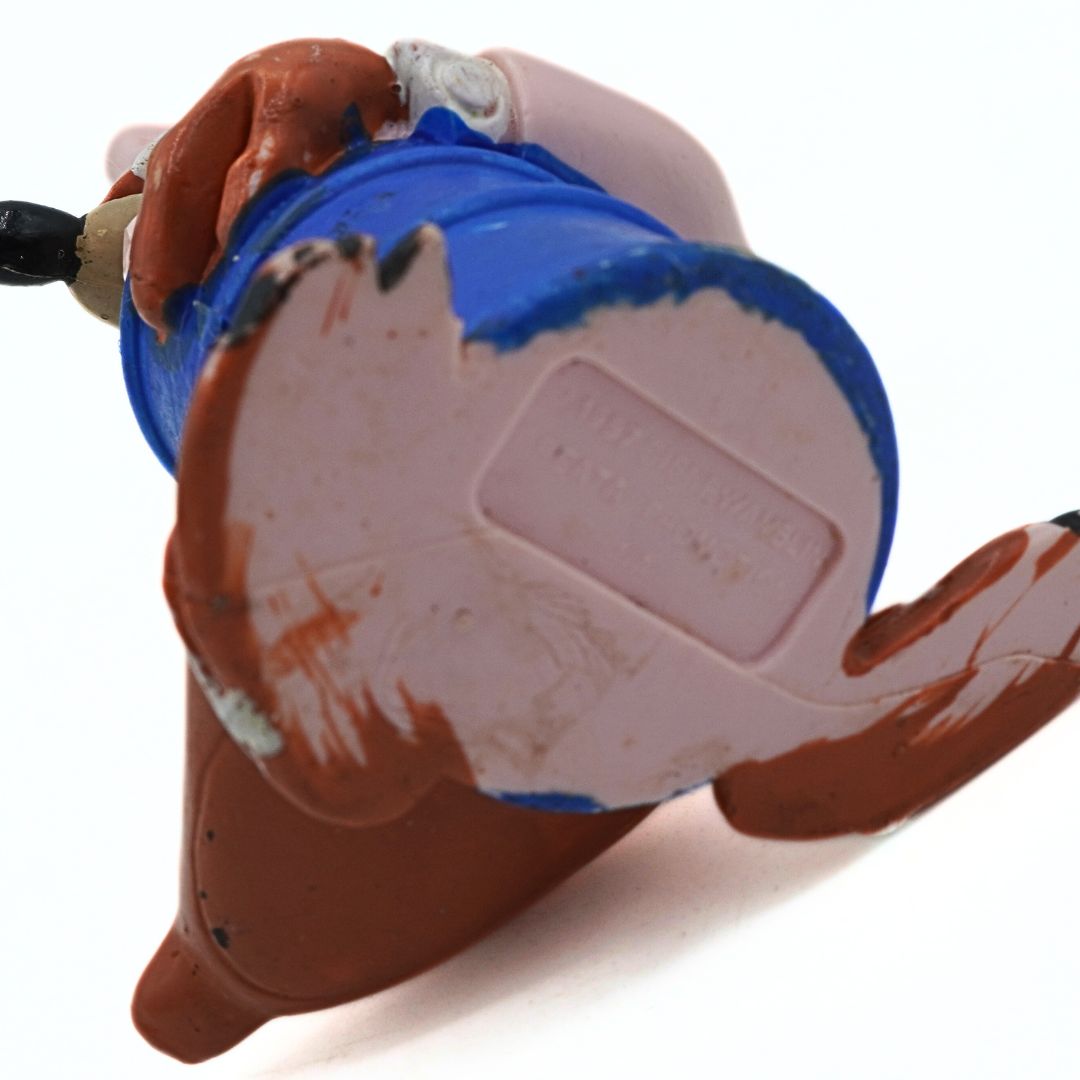 Close-up of a vintage toy with blue and brown paint on a white background