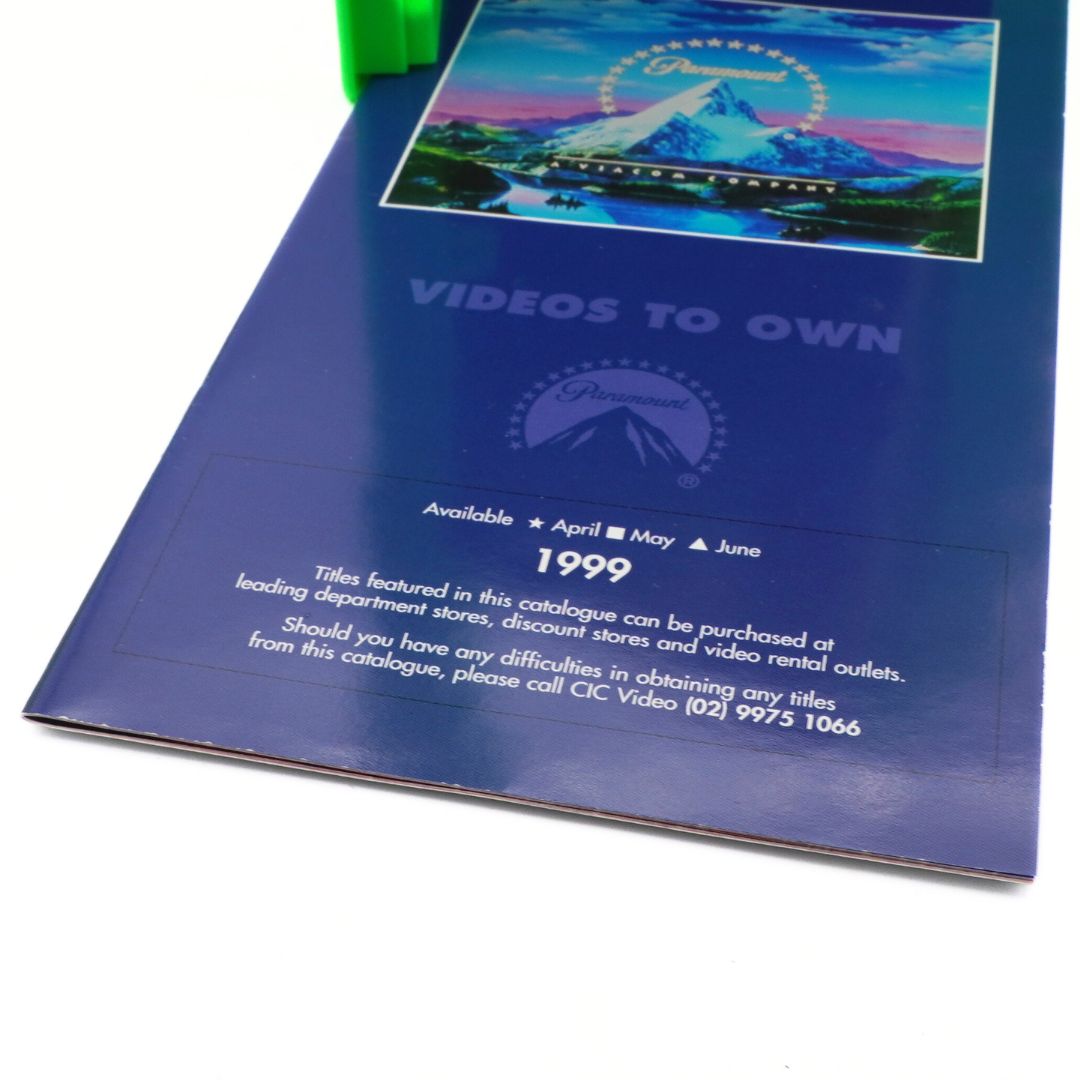 Blue video rental catalog from 1999 with a cover featuring a mountain and lake illustration.