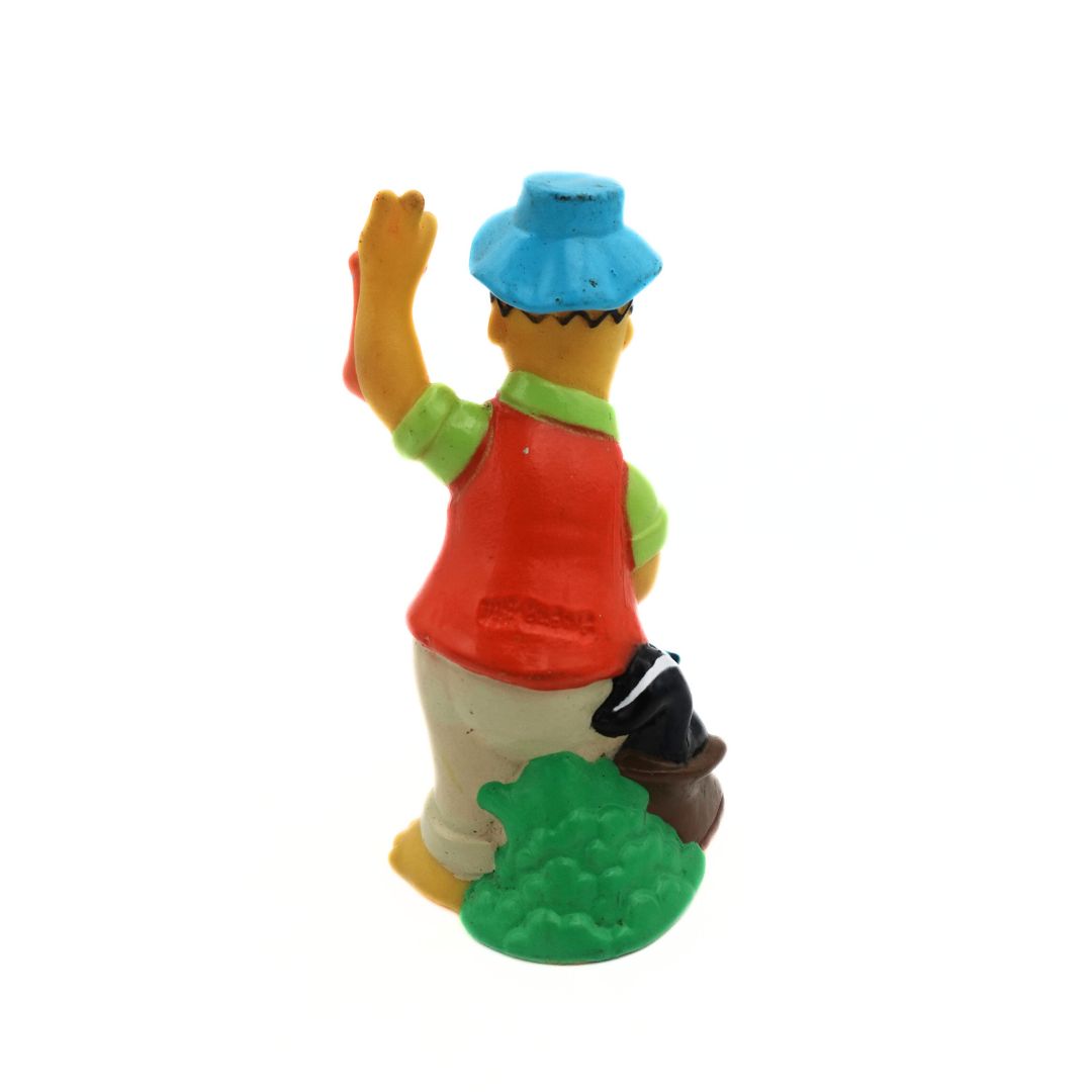 Back side of a 1990 Homer Simpson figurine in a camping outfit with a skunk