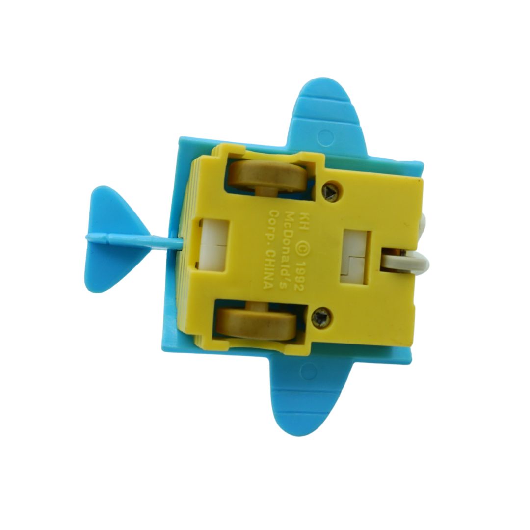 A small toy airplane with a yellow central body and blue wings, tail, and propeller, photographed on a plain white background.