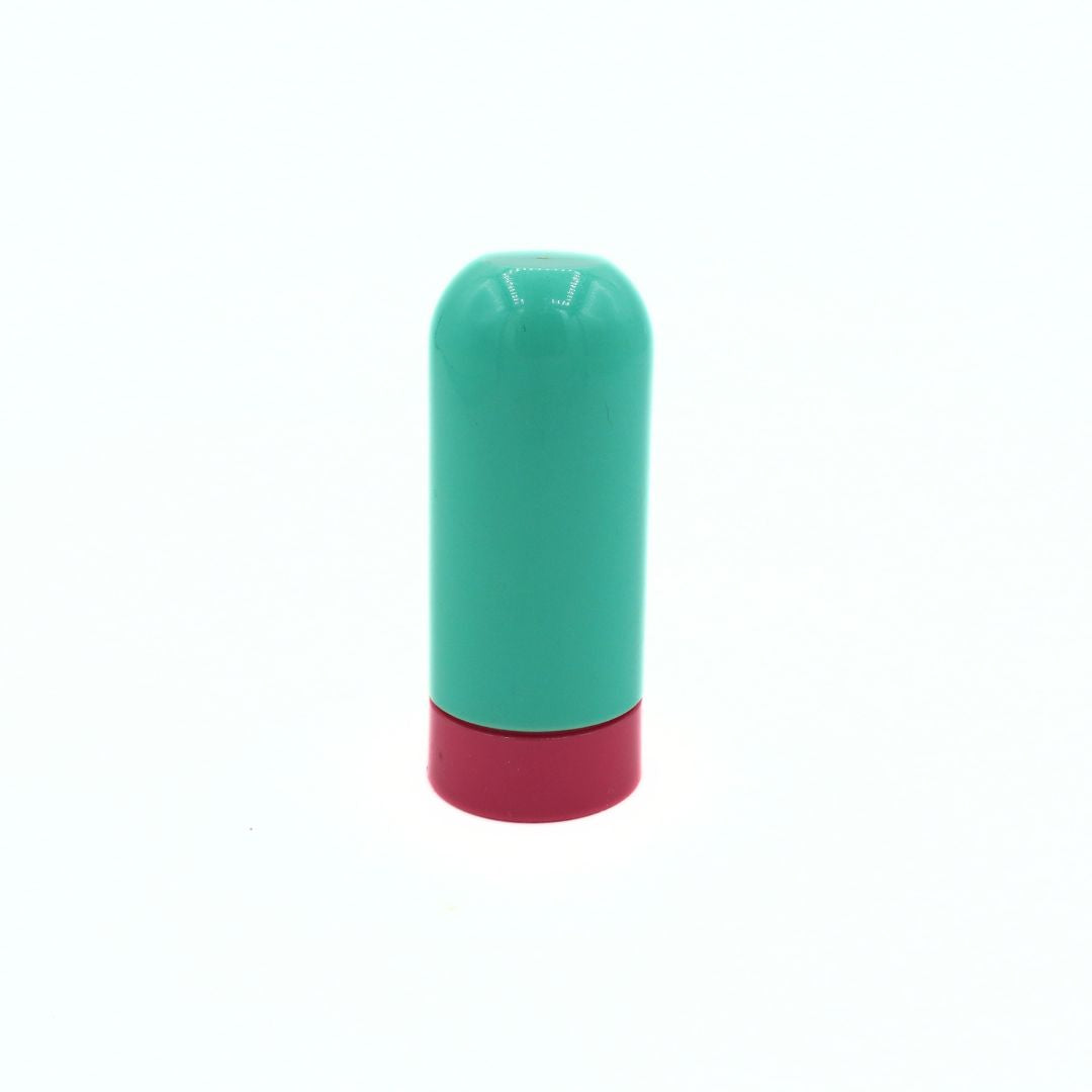 A small cylindrical cosmetic container or tube with a mint green body and a magenta-pink base, shown upright on a plain white background.