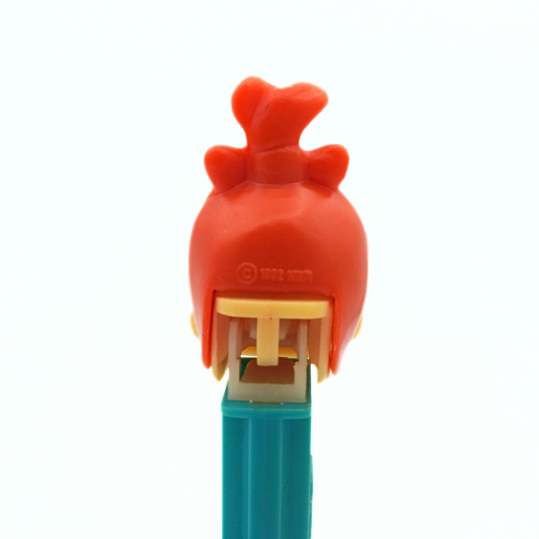 A 1992 Pebbles Pez Dispenser with red hair and a green body