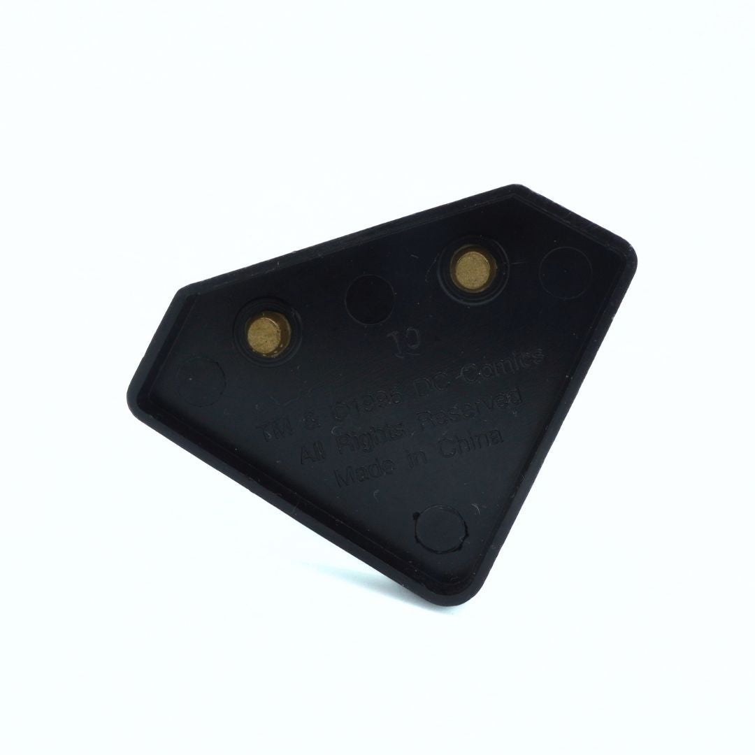 Black plastic component with three gold screws on a white background