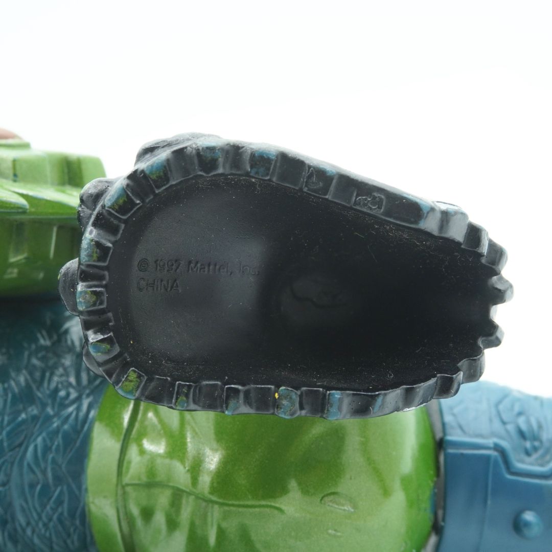 Close-up of a toy vehicle's black treaded wheel with visible branding on a blurred background.