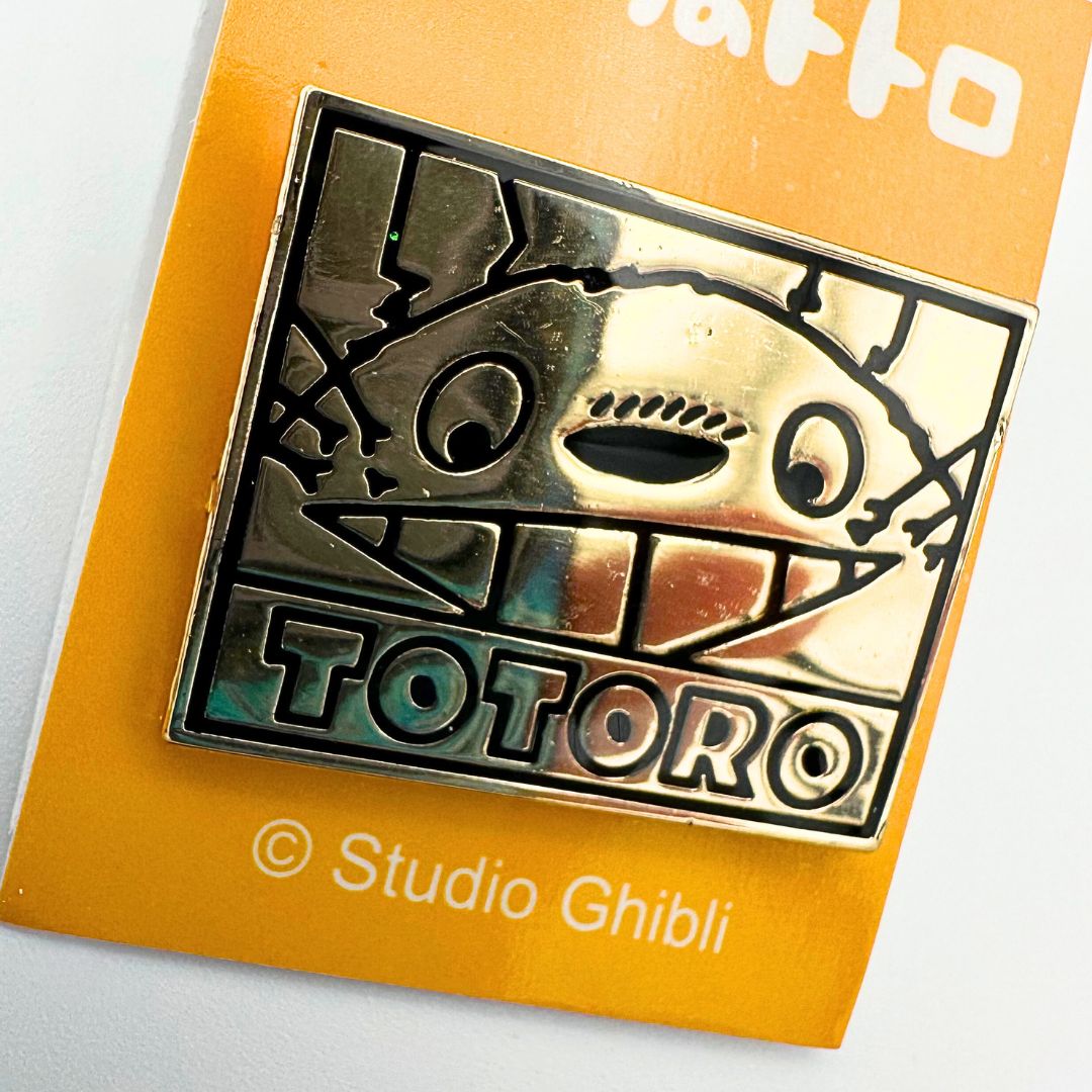 A photo of a gold toned Totoro pin made by Studio Ghibli
