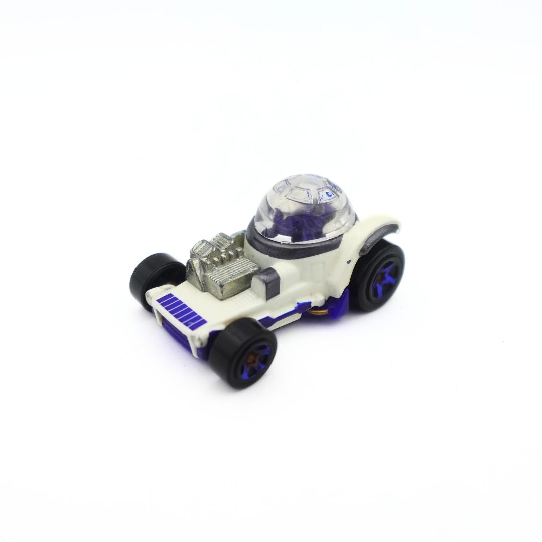 An angled photo of an R2D2 matchbox car with white, blue, silver and black detailing