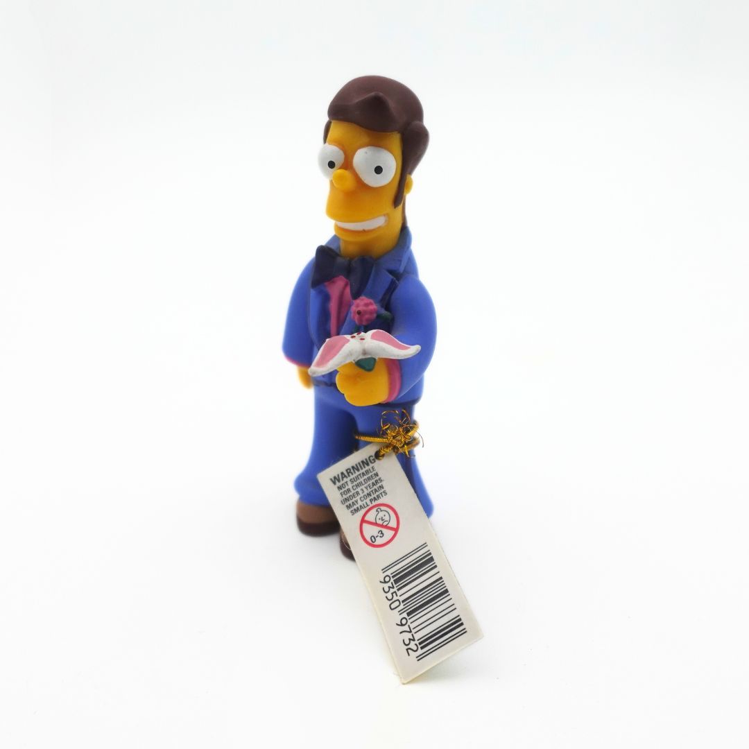 A young Homer Simpson figure holding flowers, wearing a blue suit