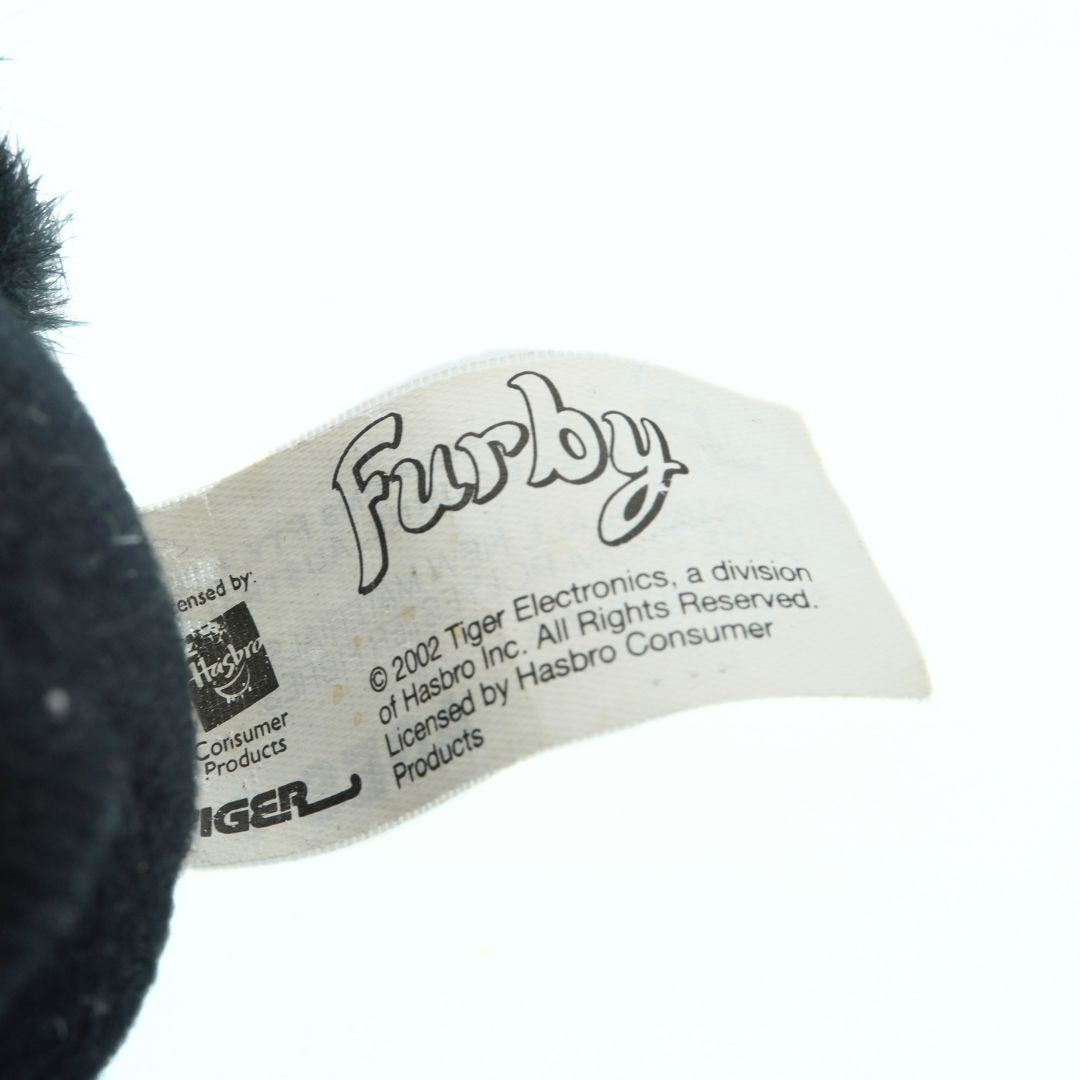 Close-up of a Furby label with branding details on a white background