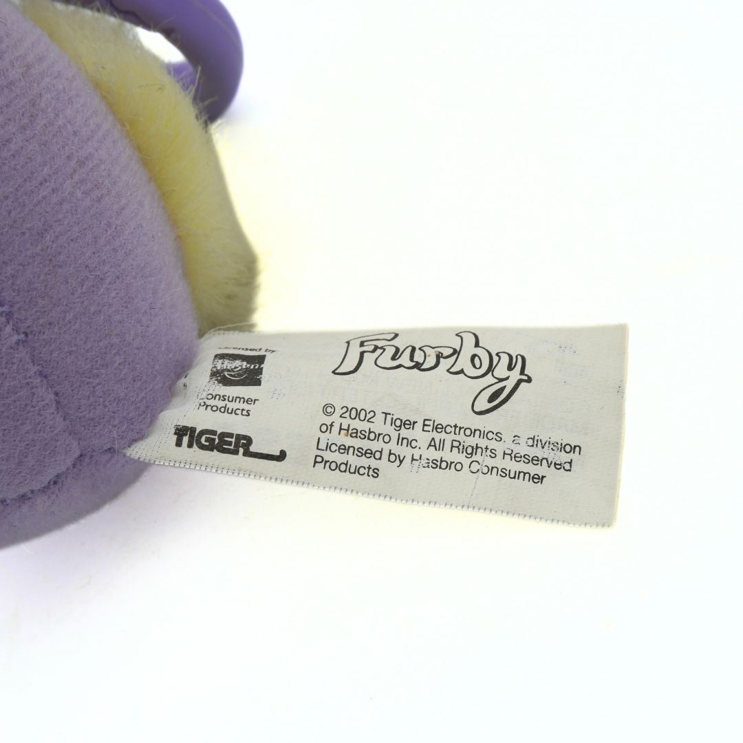 Close-up of a Furby toy label with branding details on a white background