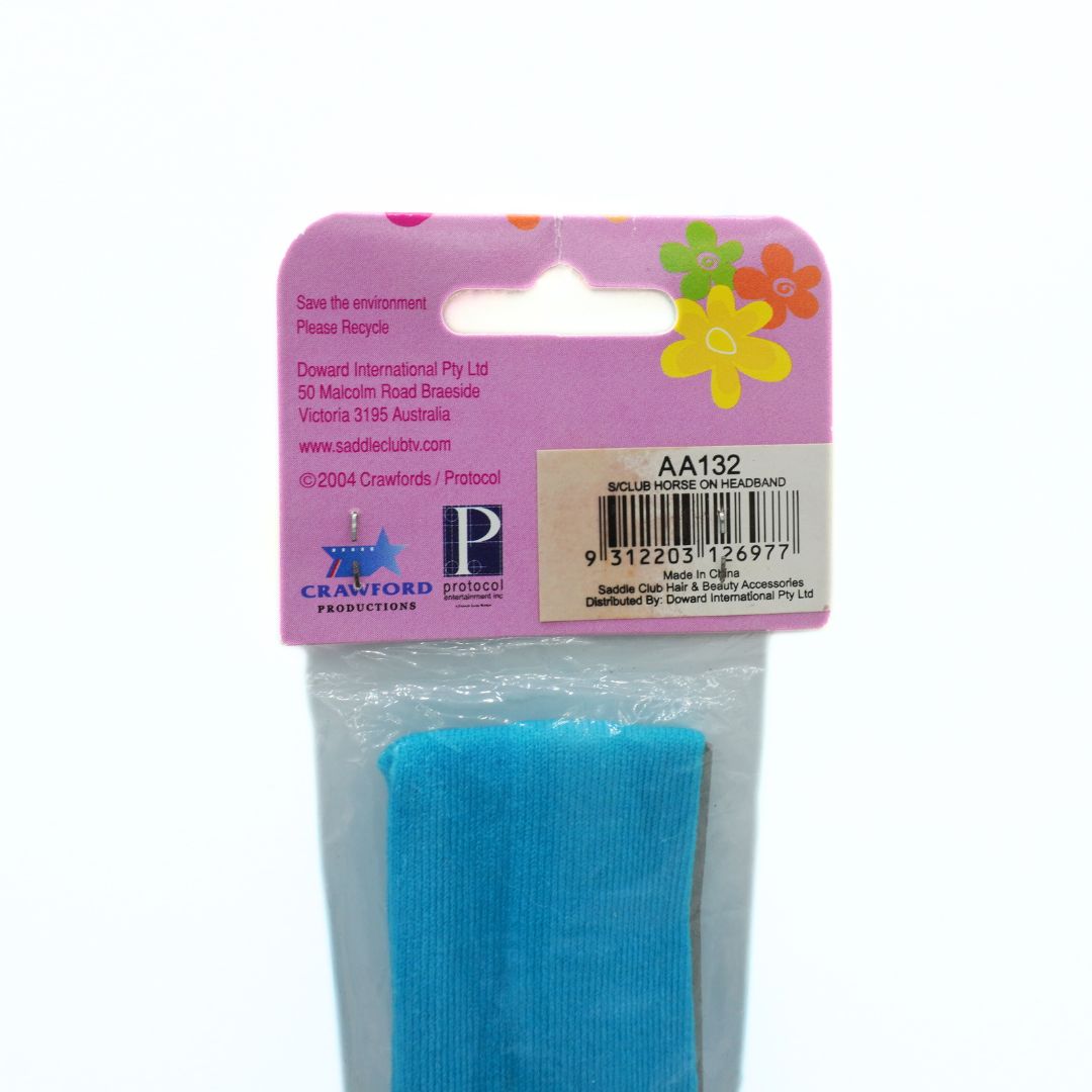 Blue hair tie in packaging with a pink label featuring branding and product details.