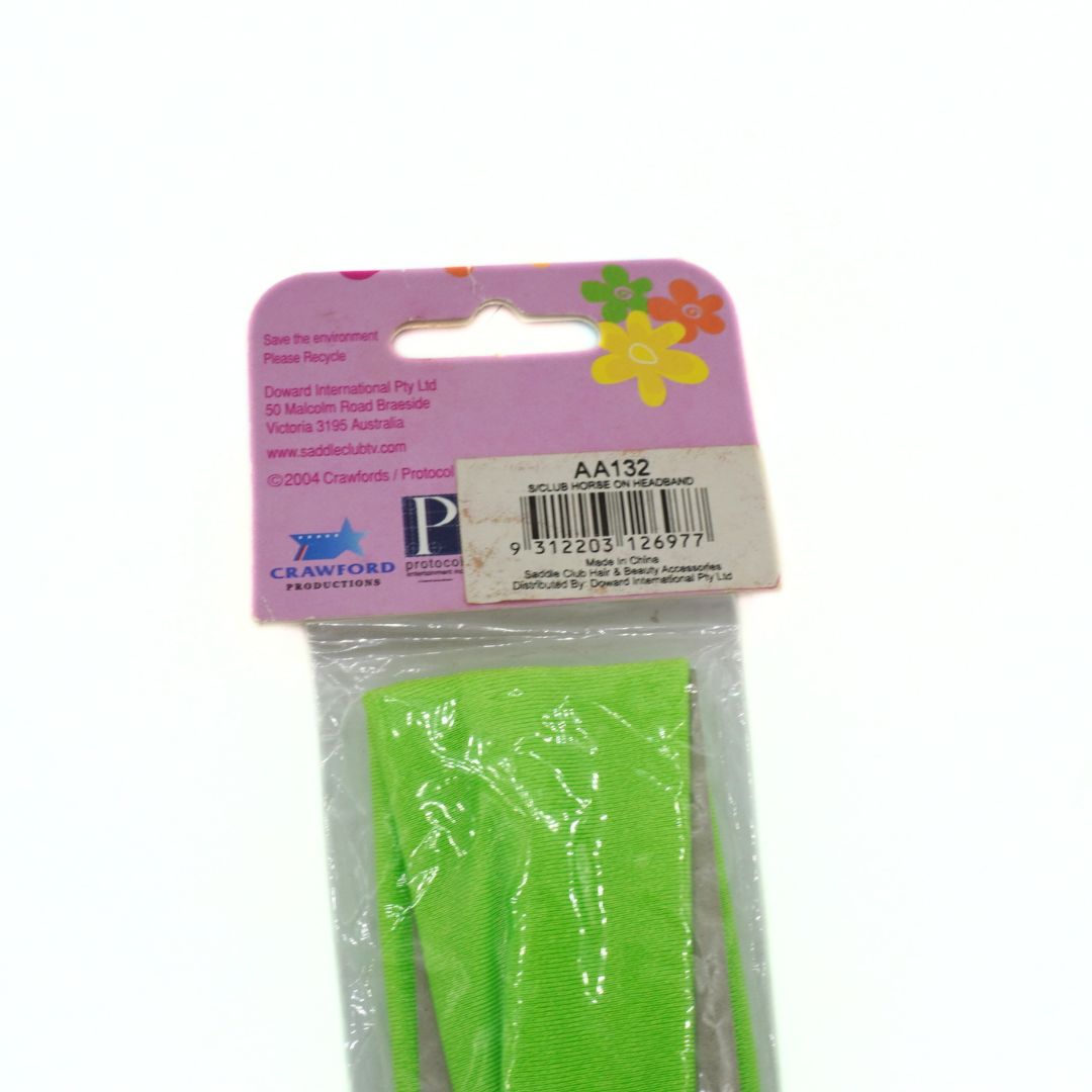 Green hair tie in clear packaging with a pink label on a white background