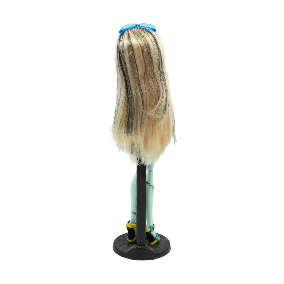 A long blonde wig with dark roots and streaks, styled with a blue headband, displayed on a black stand against a white background.