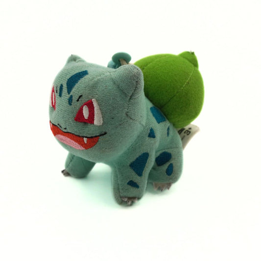 Plush toy of a character with a green leaf on its back against a white background