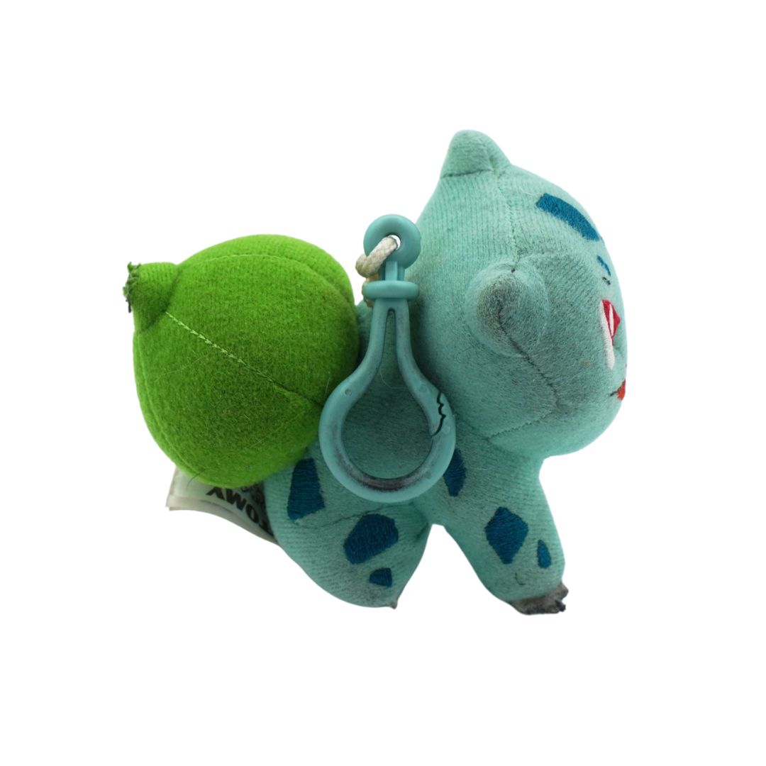 Plush keychain of a blue creature with a green leaf on a white background
