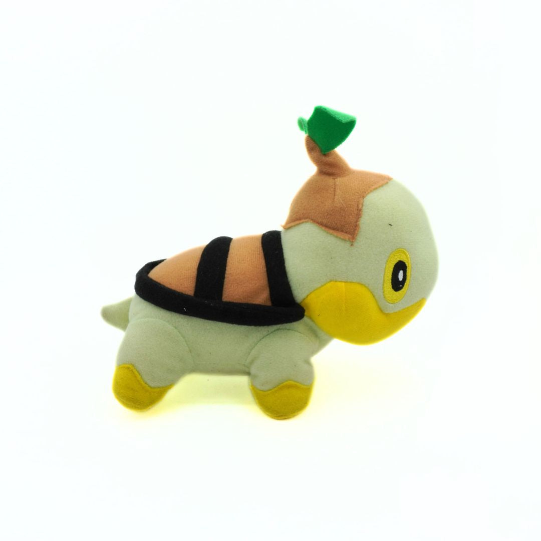 Plush toy resembling a turtle with a green shell on a white background