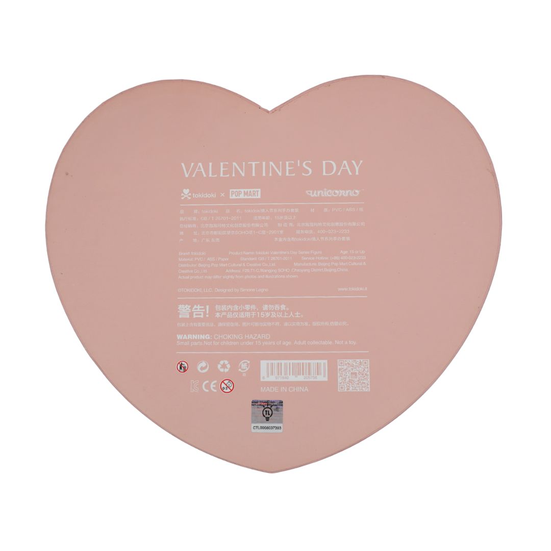 A heart-shaped pink product box or packaging insert with printed text reading 'VALENTINE'S DAY' and regulatory details, shown on a plain white background.