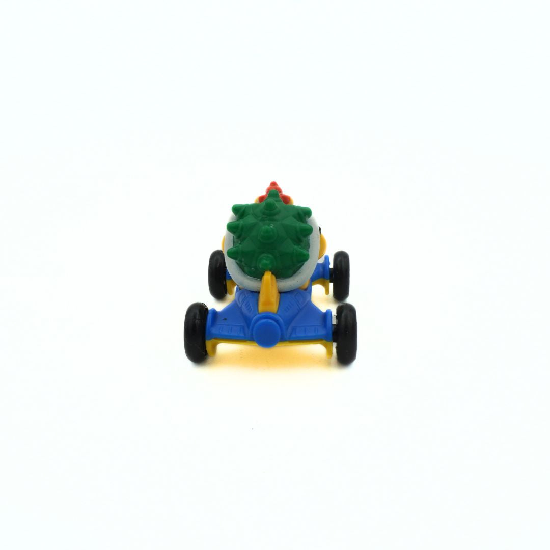 Toy figure of a character with a green shell and blue kart on a white background