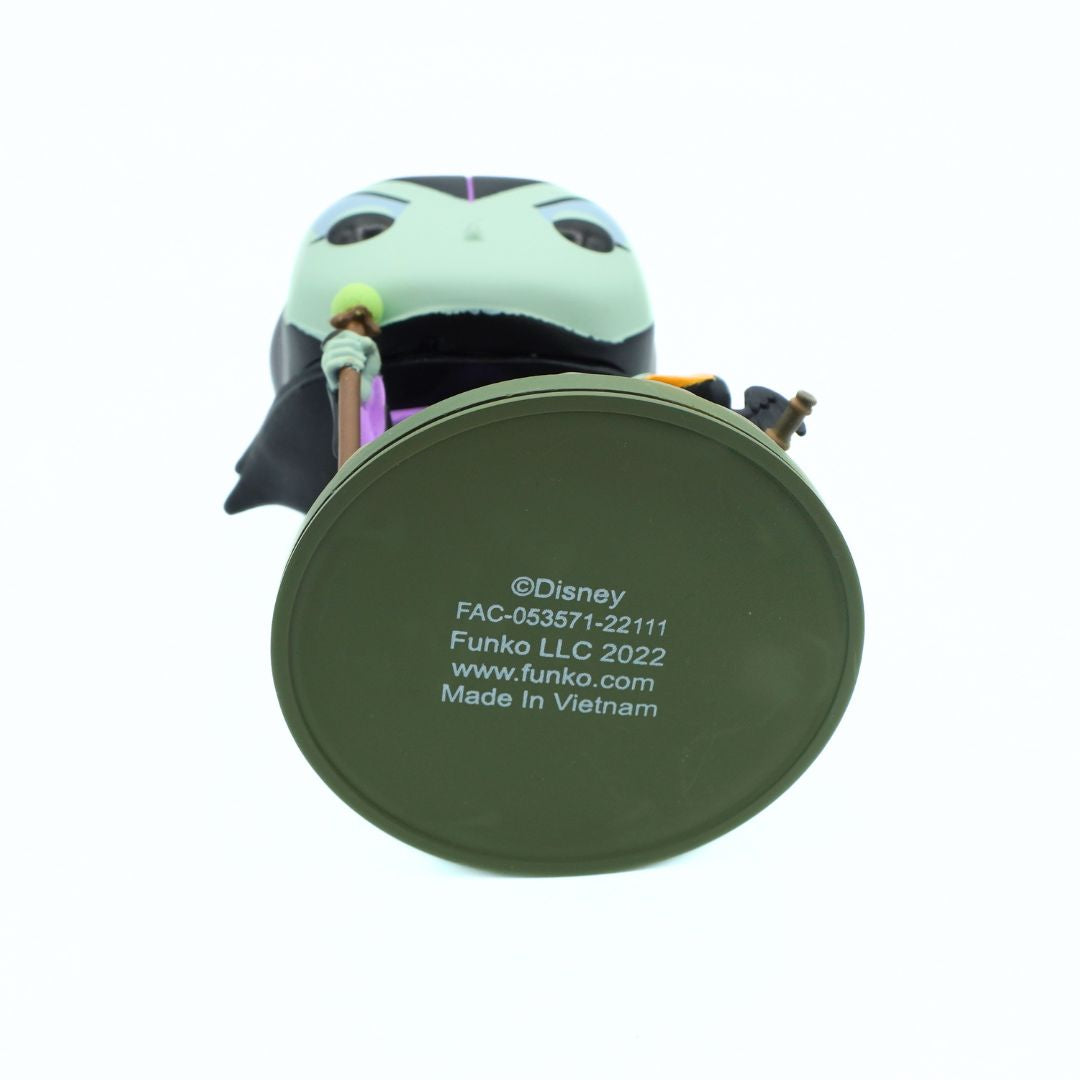 A Disney Funko figurine of Maleficent, shown from behind to display the round olive green base with printed copyright and manufacturing details.