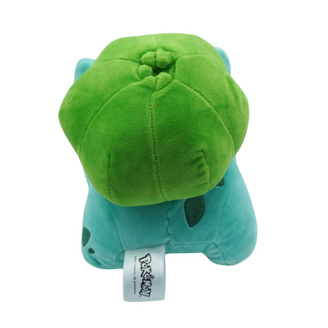 Green plush toy with a white tag on a white background