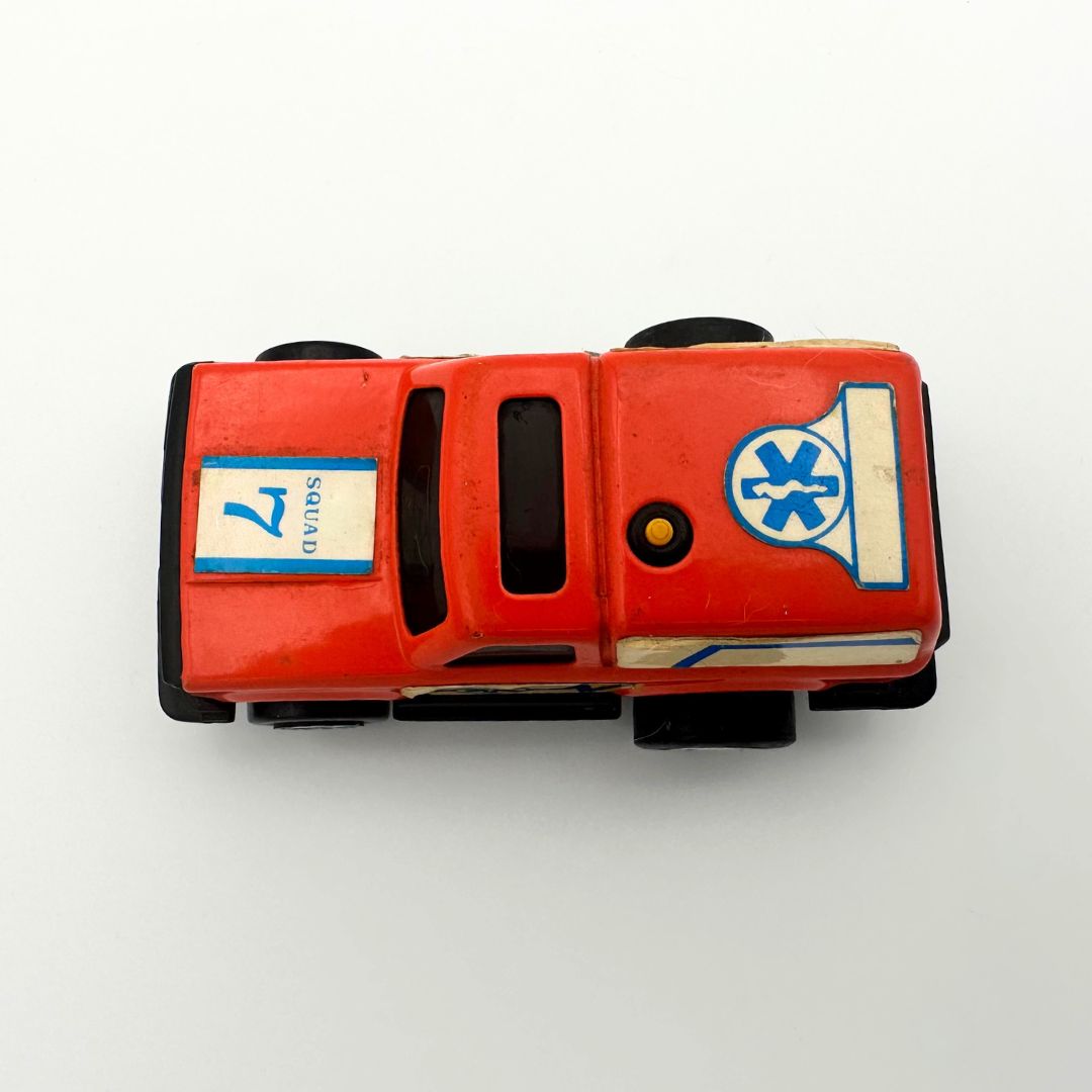 Top down image of a die-cast orange ambulance toy