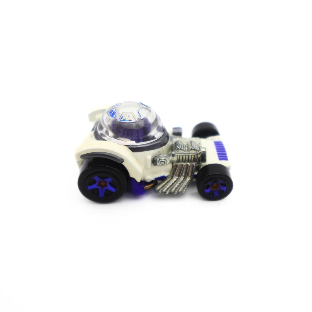 A photo of an R2D2 matchbox model car with a white body, silver chrome details, black and blue wheels